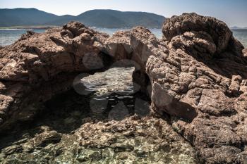 Natural stone grotto on the Mediterranean coast, South Corsica, France. Plage De Capo Di Feno. Dark tonal correction filter effect