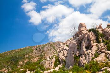 Landscape of South Corsica with rocky mountains under cloudy sky