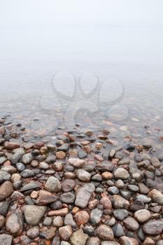 Coastal stones on Saimaa lake in foggy morning