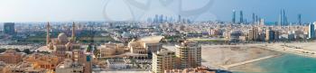 Manama, Bahrain - November 20, 2014: Bird view wide panorama of Manama city, Bahrain. Skyline with old buildings, Grand Mosque and modern skyscrapers on the coast of Persian Gulf
