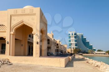 Yellow house facade fragment with classical Arabic style arch, Manama, Bahrain