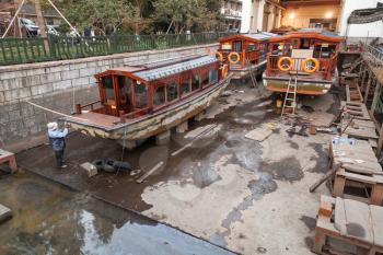 Hangzhou, China - December 5, 2014: Traditional Chinese wooden recreation boats under renovation in the shipyard. West Lake coast. Famous park in Hangzhou city, China