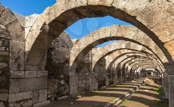 Empty corridor with arcs and blue sky. Ruins of Ancient city Smyrna. Izmir, Turkey