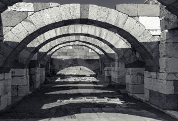 Interior of empty corridor with arcs. Ruins of Ancient city Smyrna. Izmir, Turkey. Black and white photo