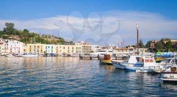 Ischia port cityscape, inner harbor with moored fishing boats
