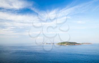 Mediterranean sea landscape with Procida island under blue cloudy sky, view from Ischia Ponte 