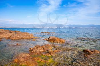 Red coastal stones on public beach of Ajaccio, Corsica, France