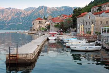 White wooden boats float moored in Perast. Kotor Bay, Montenegro