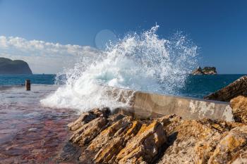 Stone breakwater with breaking waves. Adriatic Sea, Montenegro
