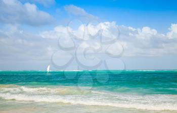 Bright sea landscape with cloudy sky and lonely sail. Atlantic ocean, Dominican republic. Punta Cana