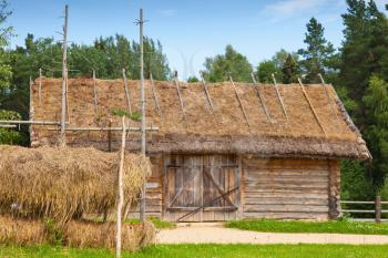 Russian rural wooden architecture example, outdoor hay drying near old wooden barn with locked gate