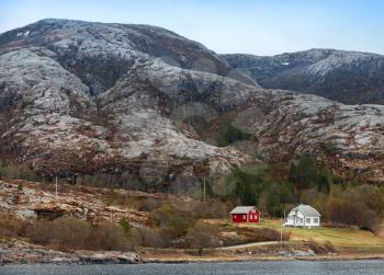Traditional small Norwegian village with red and white wooden houses on rocky coast