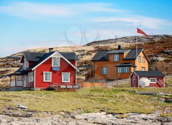 Norwegian village with colorful wooden houses on rocky sea coast