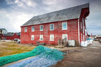 Red wooden fishing barn with drying nets. Rorvik town, Norway