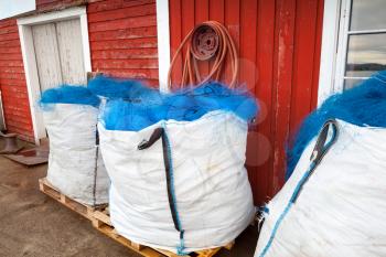 Packed blue fishing nets lay in small Norwegian village