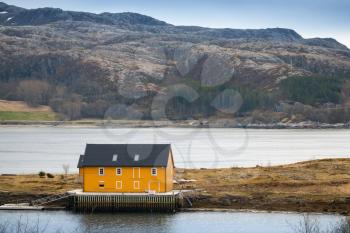 Norwegian village with yellow wooden house on Sea coast