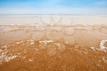 Fragments of ice on empty sandy coast of Baltic Sea