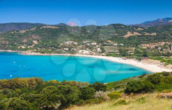 Summer coastal landscape of Corsica. Small azure bay with beach. Piana region, France