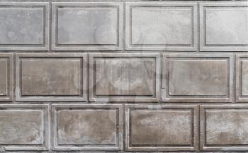 Old gray stone wall with decorative relief pattern, background photo texture