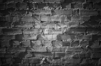 Black brick wall with spot illumination, frontal flat detailed background texture