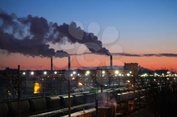 Industrial cityscape with smoke of chimneys and railroads