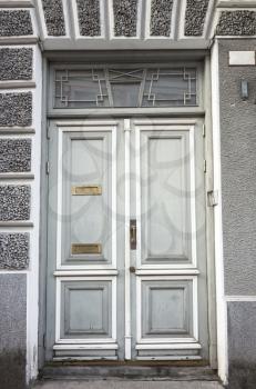 Gray wooden door with decoration pattern in old building facade. Tallinn, Estonia