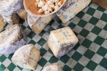 Dutch blue cheese pieces lay on checkered tablecloth, Amsterdam marketplace counter