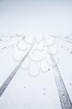 Empty snowy road in cold winter season, Reykjavik district, Iceland. Vertical photo
