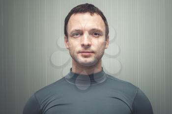Front face portrait of young European man in gray sportswear