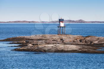 Traditional Norwegian steel lighthouse with solar battery and conical red top