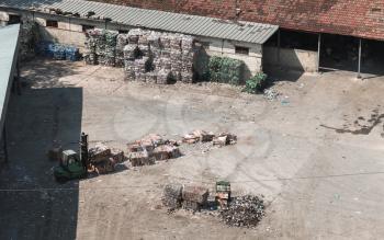 Industrial garbage sorting. Forklift forms blocks of plastic and paper for recycling