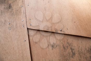 Structure made of plywood sheets connected with rivets, background photo texture