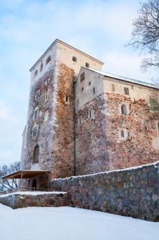 Turku Castle in winter, vertical photo. Medieval building in the city of Turku in Finland. It was founded in the late 13th century and stands on the banks of the Aura River