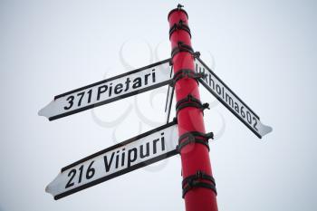 Red signpost, directional signs with distances to cities. Savonlinna, Finland