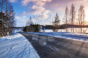 Empty rural road on a lake coast, winter landscape, Finland