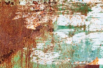 Old grunge metal wall with peeling paint layers and big rust spots, close-up background photo texture