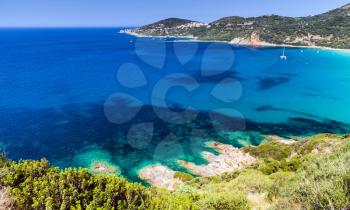 Coastal landscape of South Corsica. Small azure bay with sailing yachts, Piana region, France