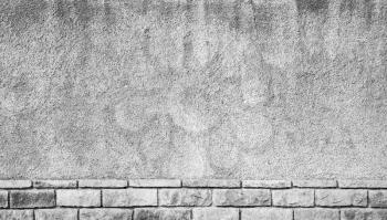 Abstract urban background texture. Gray grungy concrete wall with brick base