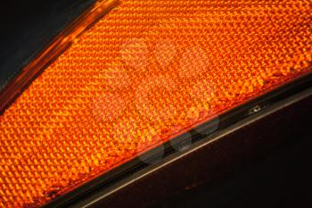 Modern car headlight fragment, orange cataphyte pattern