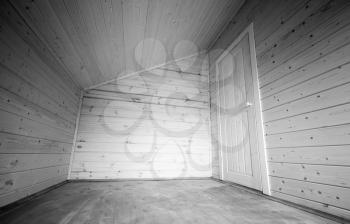White door in the corner of empty room. Wooden house interior. Black and white