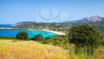 Summer coastal landscape of Corsica. Small azure bay with sandy beach. Piana region, France
