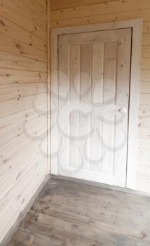 Empty wooden interior fragment, white door in the corner
