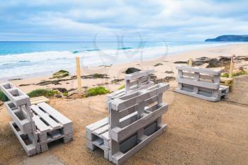 Standard white wooden furniture made of cargo pallets, seaside bar terrace. Porto Santo island, Madeira archipelago, Portugal