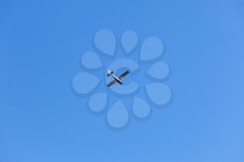 Light single-engine aircraft flies in blue sky