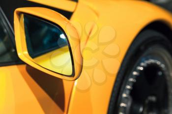 Yellow sports car mirror, close up photo. Italian car design