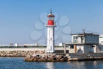 White lighthouse tower with red top stands on the entrance breakwater in Burgas port, Black Sea coast, Bulgaria
