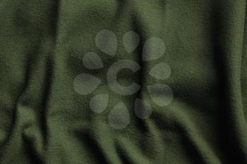 Texture of green fleece, soft napped insulating fabric made from polyester, wavy pattern