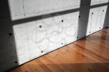 Concrete wall and wooden parquet floor with sunlight pattern. Contemporary empty interior background photo