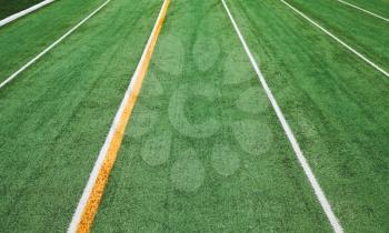 Empty running track background with artificial turf field and border lines