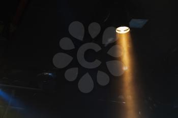 Ray of scenic spot light in smoke over dark background, stage illumination equipment